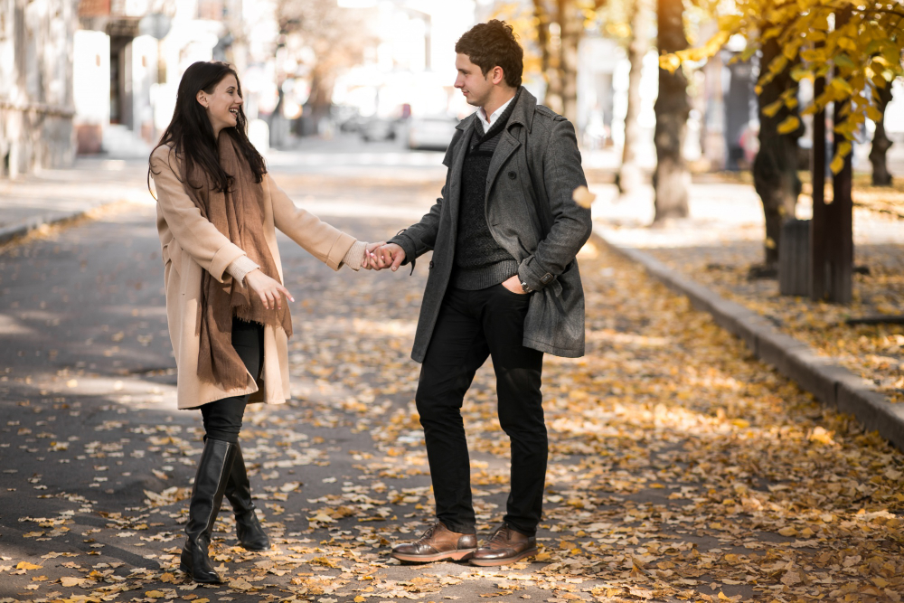 Happy couple spending quality time together, walking hand-in-hand through a serene park, symbolizing love and understanding.